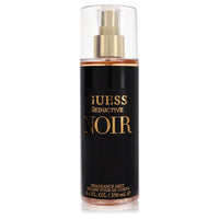 Dark blue bottle of Guess Seductive Noir body mist with gold accents, standing on a white surface, labeled "8.4 oz / 250 ml" 