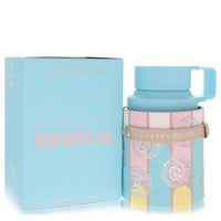 A clear glass perfume bottle with a pink label and gold accents, standing on a white surface, labeled "Armaf Odyssey Marshmal