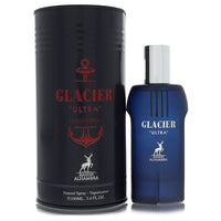 A blue glass bottle with a silver cap, standing on a wooden surface, labeled "Maison Alhambra Glacier Ultra" by The Fragrance