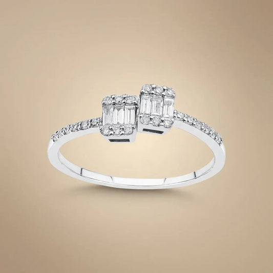 A 14ct white gold ring with two baguette diamonds and a 0.25ct center diamond, featuring an open design by Majestic Jewellery