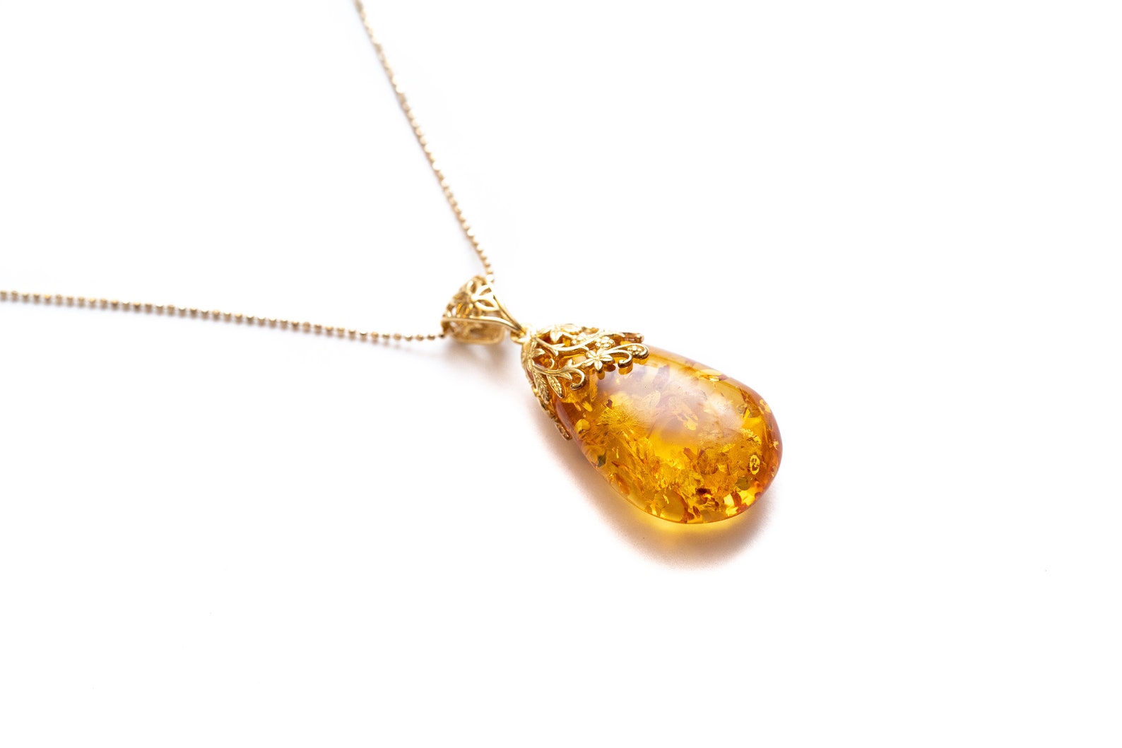 Pendentif gouttelette ambrée à l'accent floral doré